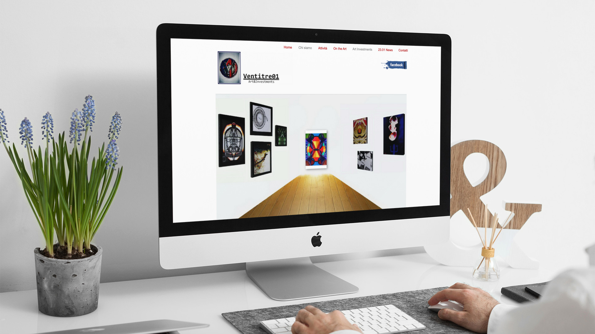 Uomo che guarda sull'iMac la home page del sito web di Ventitre01 di Roma