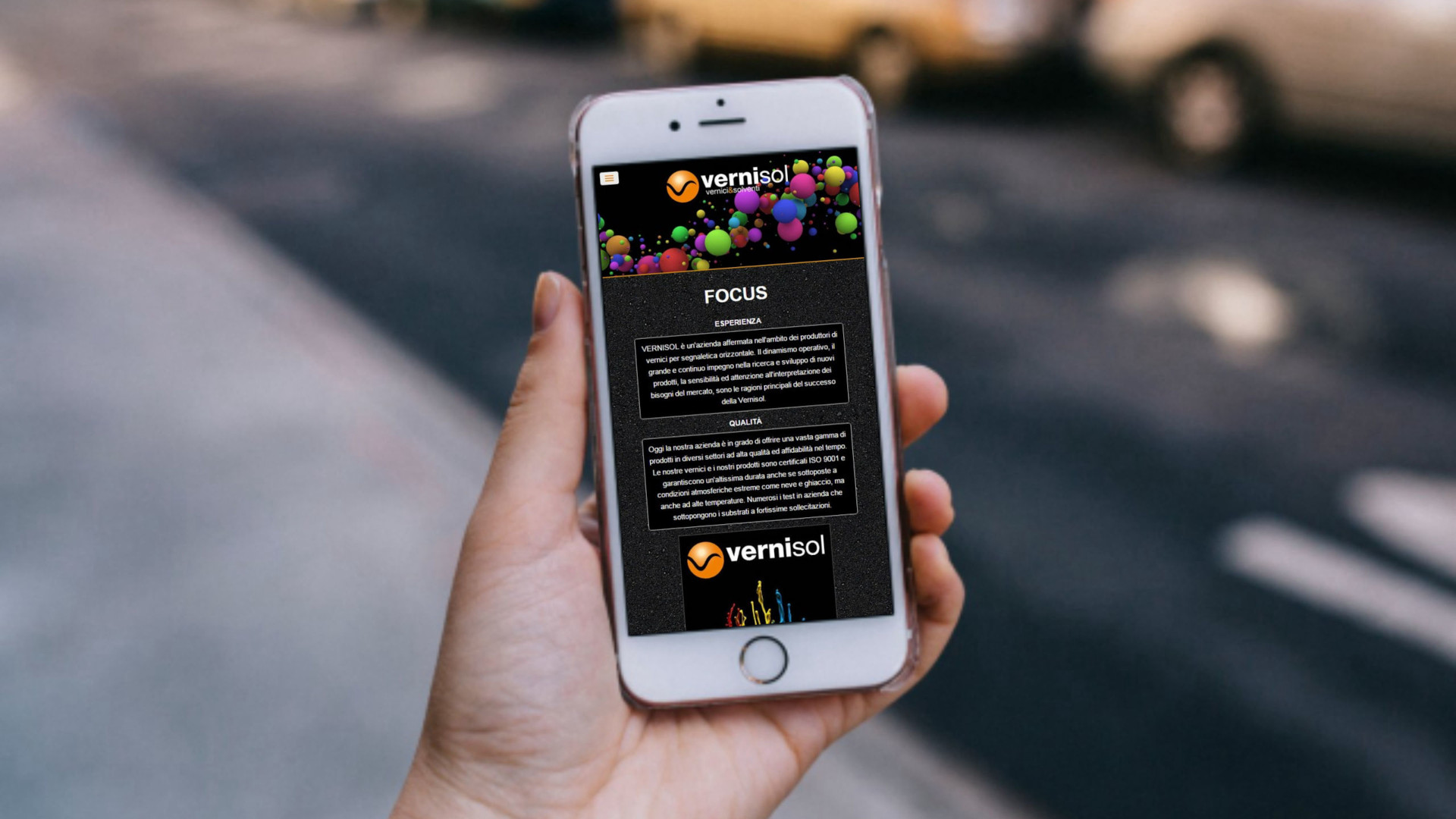 Mano con iPhone che mostra il sito web in modalità mobile responsive della Vernisol spa di Cremona