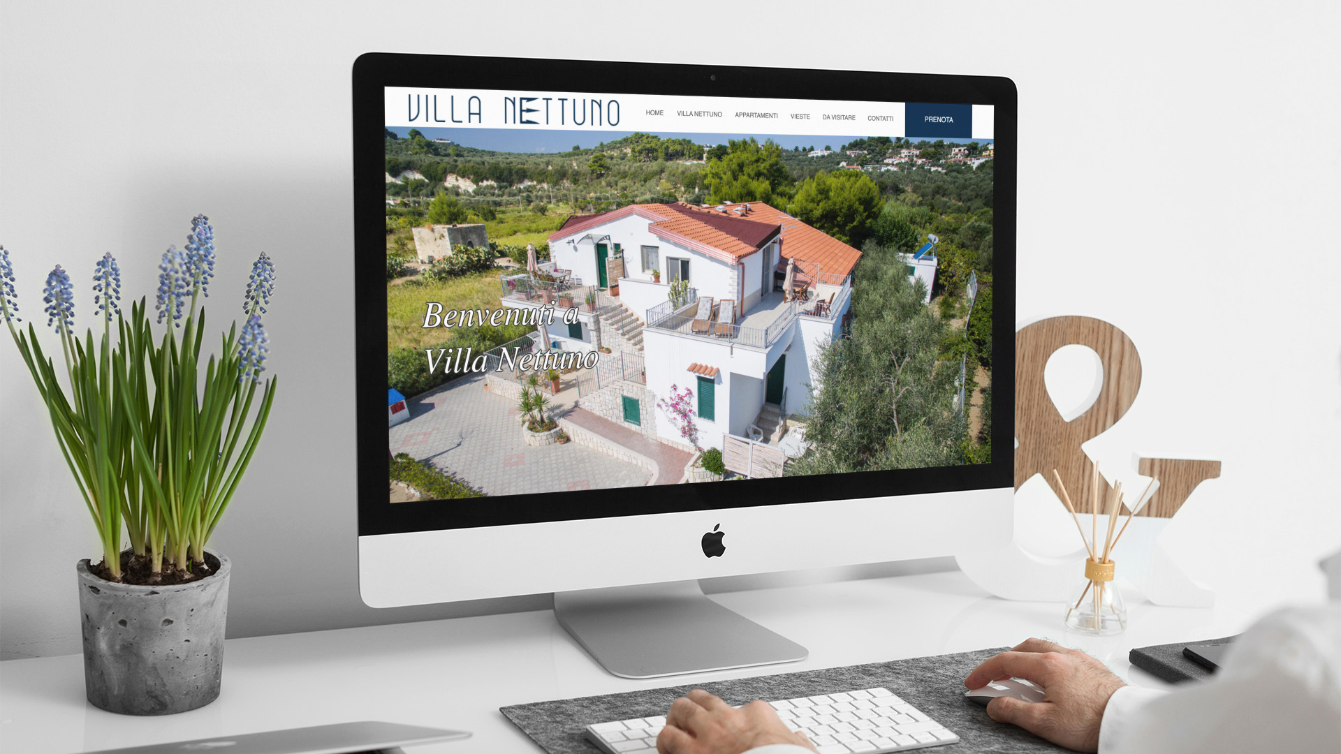 Uomo che guarda sull'iMac la home page del sito web della Villa Nettuno di Vieste
