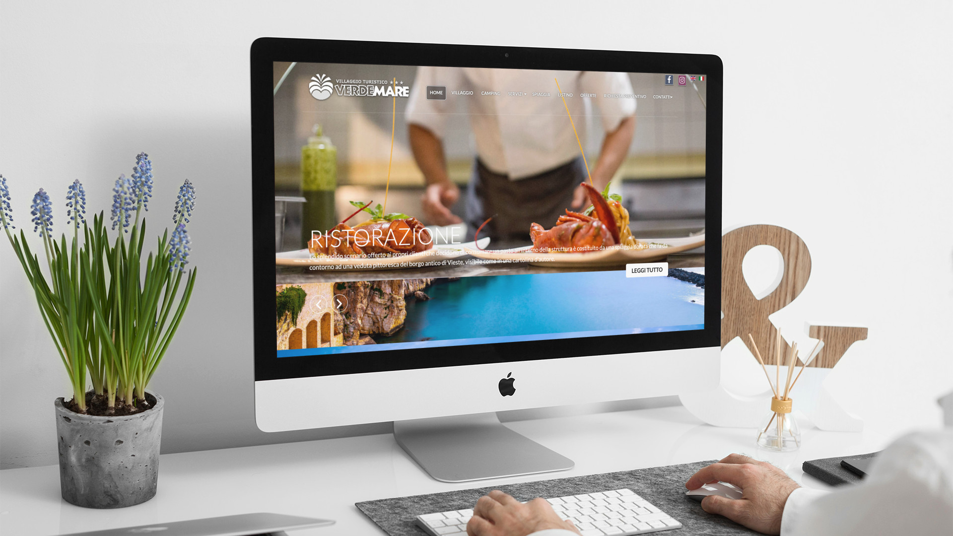 Uomo che guarda sull'iMac la home page del sito web del Villaggio Verdemare di Vieste