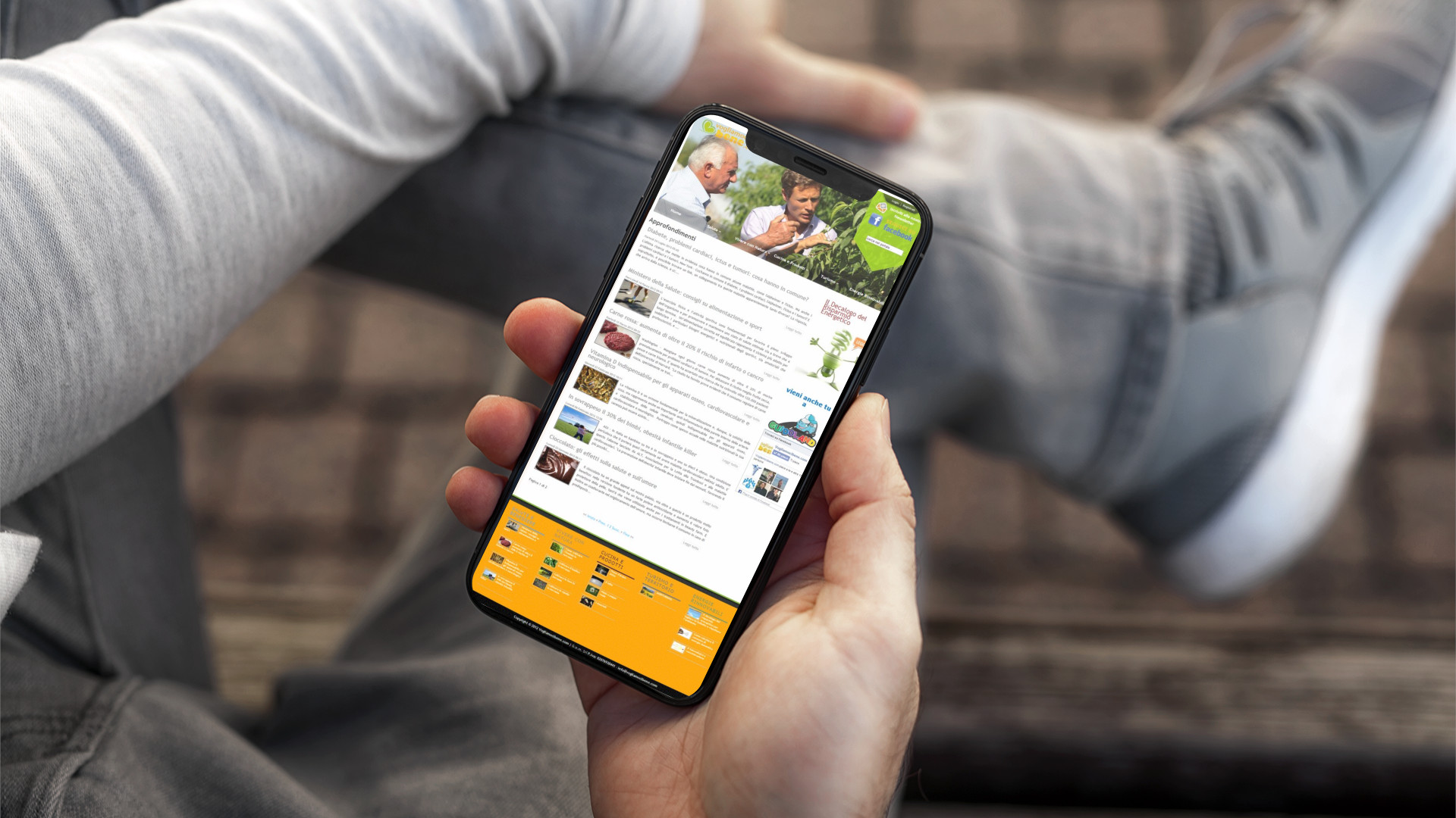 Mano con iPhone che mostra il sito web in modalità mobile responsive di Vogliamoci Bene