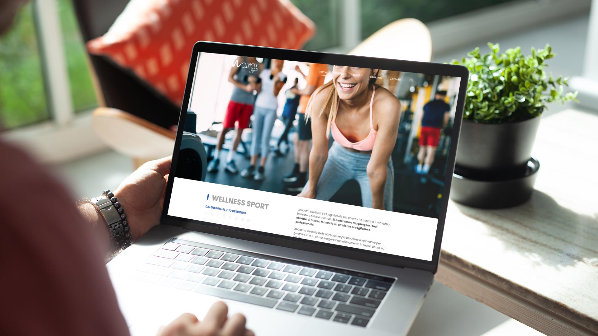 Uomo a casa con MacBook Pro guarda il Sito Web wellnessteramo.it