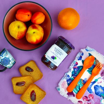 Confettura di frutti di bosco con biscotti e frutta su sfondo viola