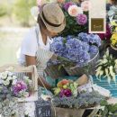 Fiorista mentre prepara un bouquet colorato all'aperto