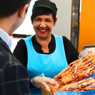 Addetta di Mediterranea Surgelati a Teramo mostra una confezione di gamberi
