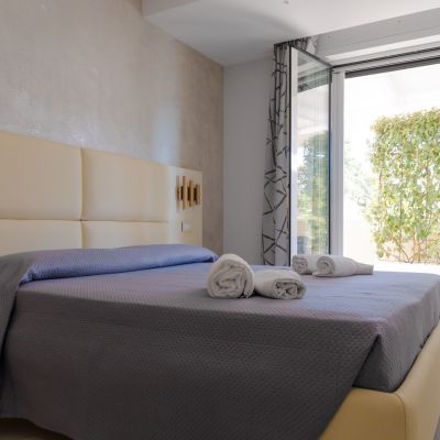 Camera della suite Iris con letto matrimoniale e porta aperta sul patio