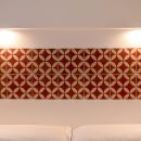 Testiera decorata nei toni del rosso sopra il letto matrimoniale
