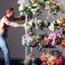 Uomo mentre sistema una grande parete di composizioni floreali
