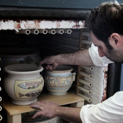 Artigiano De Fabritiis mentre estrae i vasi in ceramica dal forno