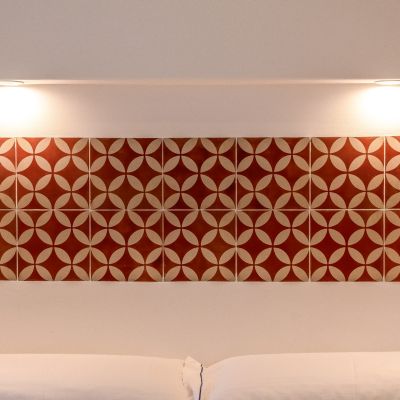 Testiera decorata nei toni del rosso sopra il letto matrimoniale