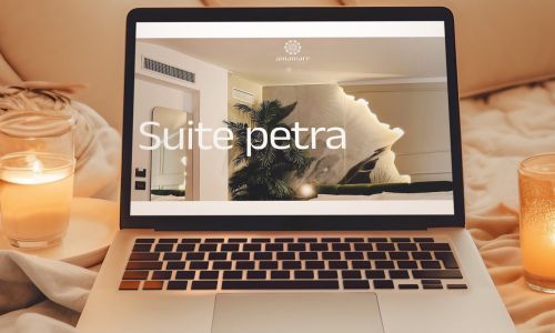 mockup notebook sul letto con candele accese che mostra la pagina della Suite Petra del sito web AmaMare Bed and Breakfast a Giulianova Lido realizzato da Wainet Web Agency Teramo