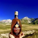 Bottiglia di liquore alla genziana Scuppoz davanti al paesaggio di Campo Imperatore