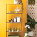 Scaffale giallo con vasi, cornici e complementi d'arredo