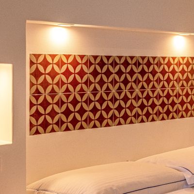 Letto della camera Rossa con testiera decorata e luci laterali