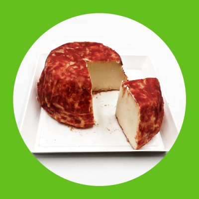 Formaggio pecorino con crosta al peperoncino fotografato su fondo bianco