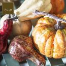 Zucche decorative autunnali con foglie e tessuti