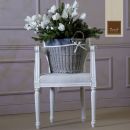 Sedia bianca con cesto di fiori bianchi
