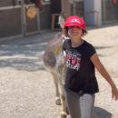 Bambina con cappellino rosso accompagna un pony al Maneggio Team Horse