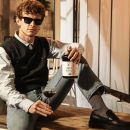 Ragazzo con occhiali mentre regge il liquore alla liquirizia Scuppoz e un calice