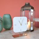 Vaso verde, orologio bianco e lanterna su sfondo rosa