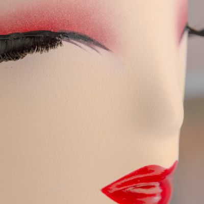 Dettaglio del volto di un manichino con trucco rosso