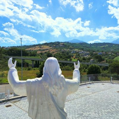 Statua di Cristo rivolta verso il paesaggio davanti alla casa funeraria