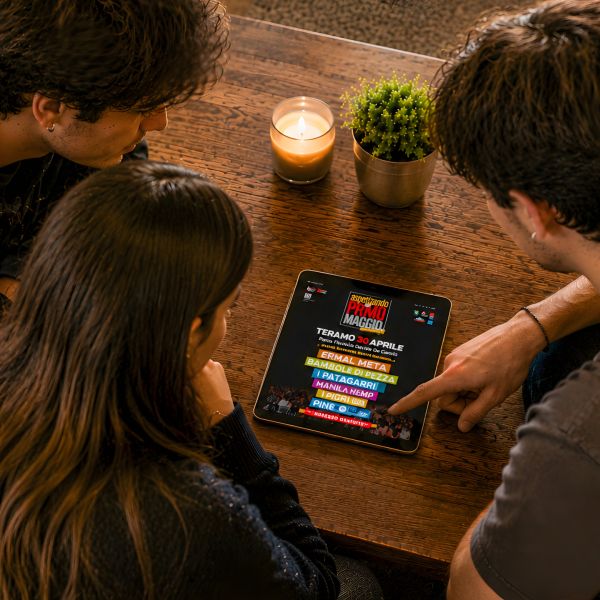 ragazzi che guardano sul tablet la Home Page del sito web di Aspettando Il Primo Maggio di Teramo realizzato da Wainet Web Agency a Teramo in Abruzzo