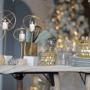 Tavola elegante con lampade metalliche e accessori argentati
