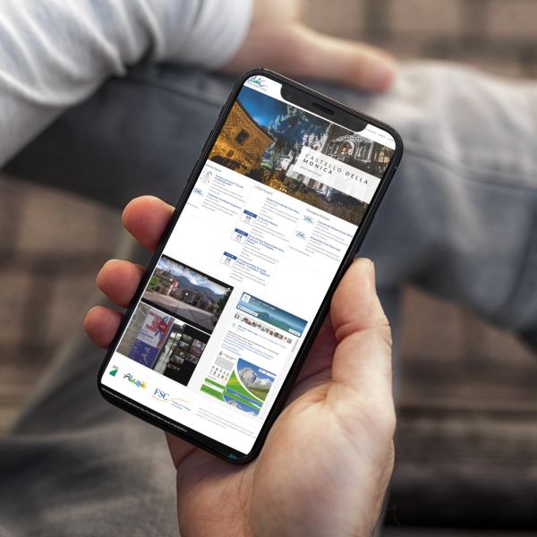 mano con Iphone che mostra il sito web in modalità mobile responsive della DMC Gran Sasso Laga di Teramo