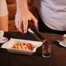 Cameriere serve vino cotto accanto a caffè e dessert alla Tacchinella