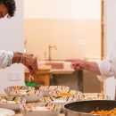 Cuoco mentre serve i piatti preparati per la cena agli ospiti