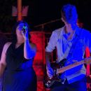 Cantante e chitarrista ripresi sotto le luci rosse del palco