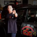 Addetta Gran Sasso Gomme davanti a un'automobile in officina