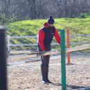Istruttrice del Team Horse mentre prepara un ostacolo nel campo di equitazione