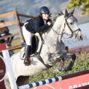 Amazzone del Team Horse con cavallo grigio durante un salto a ostacoli