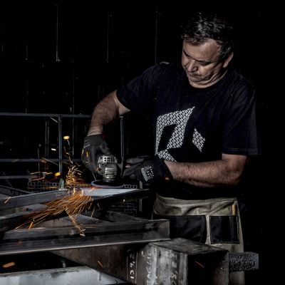 Operatore durante il taglio di un profilato metallico con la mola