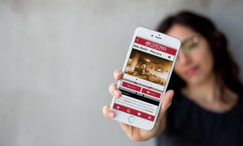 Ragazza mostra la pagina ristorante dell'app Arrosticini d'Abruzzo per iOS e Android realizzata da WAINET Web Agency Abruzzo Teramo