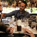 Tre persone sorridono e brindano con calici di Gin Scorretto Scuppoz