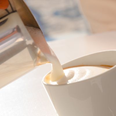 Latte versato nella tazza durante la colazione