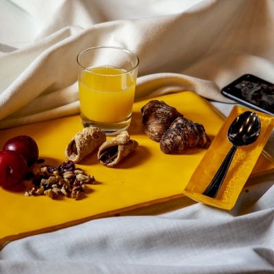 Vassoio in vetro giallo con frutta, dolci e succo d'arancia