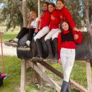 Gruppo di ragazze del Team Horse in divisa rossa al maneggio di Teramo
