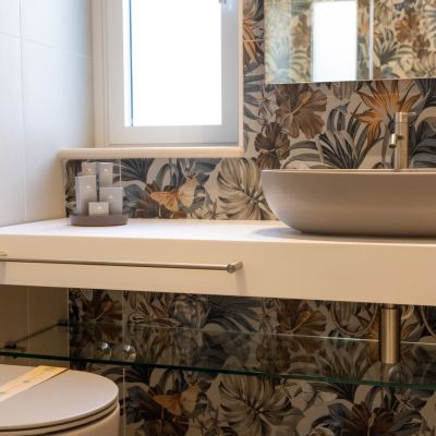 Lavabo bianco e piastrelle botaniche nel bagno della suite Tulipano