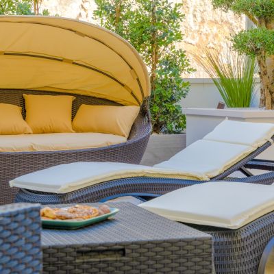 Terrazza della suite Tulipano con letto a baldacchino, lettini e vasca idromassaggio