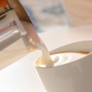Latte versato nella tazza durante la colazione