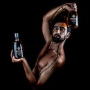 Shooting fotografico body painting professionale ragazzo con bottiglia liquore di genziana Scuppoz