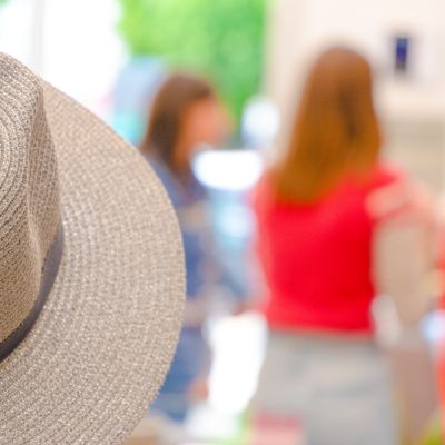Cappello in primo piano con clienti sfocate sullo sfondo
