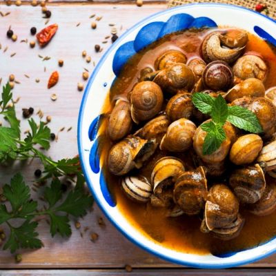 Piatto di chiocciole cucinate con erbe aromatiche