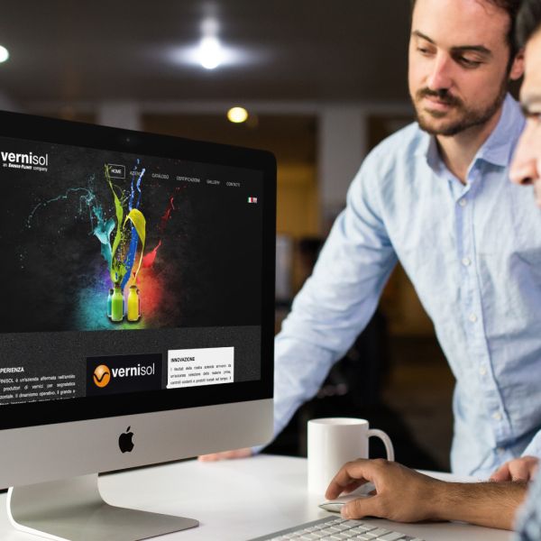 ingegneri che guardano sull'iMac la home page del sito web della Vernisol Spa di Cremona