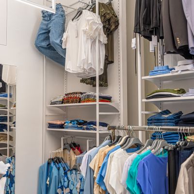 Interno di Altra Idea Moda con scaffali e capi nelle tonalità azzurre