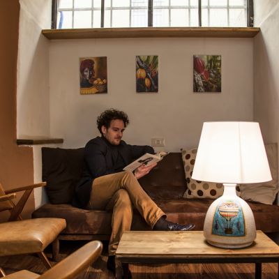 Lampada in ceramica della collezione Terzo Cielo accanto a un lettore